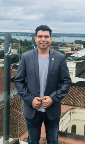 Rodrigo Sánchez en traje, con edificios de fondo.