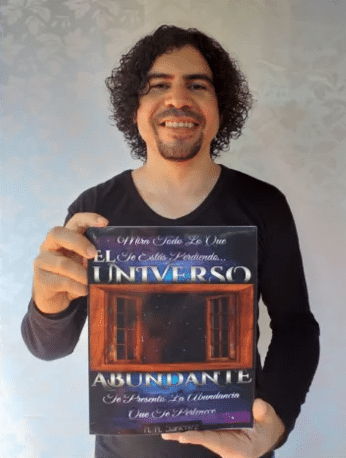 Rodrigo Sánchez sosteniendo uno de sus libros: El universo abundante.